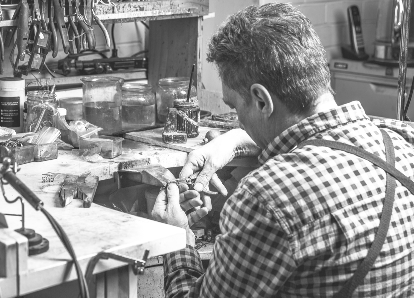 A master jeweller handcrafting a ring at the bench